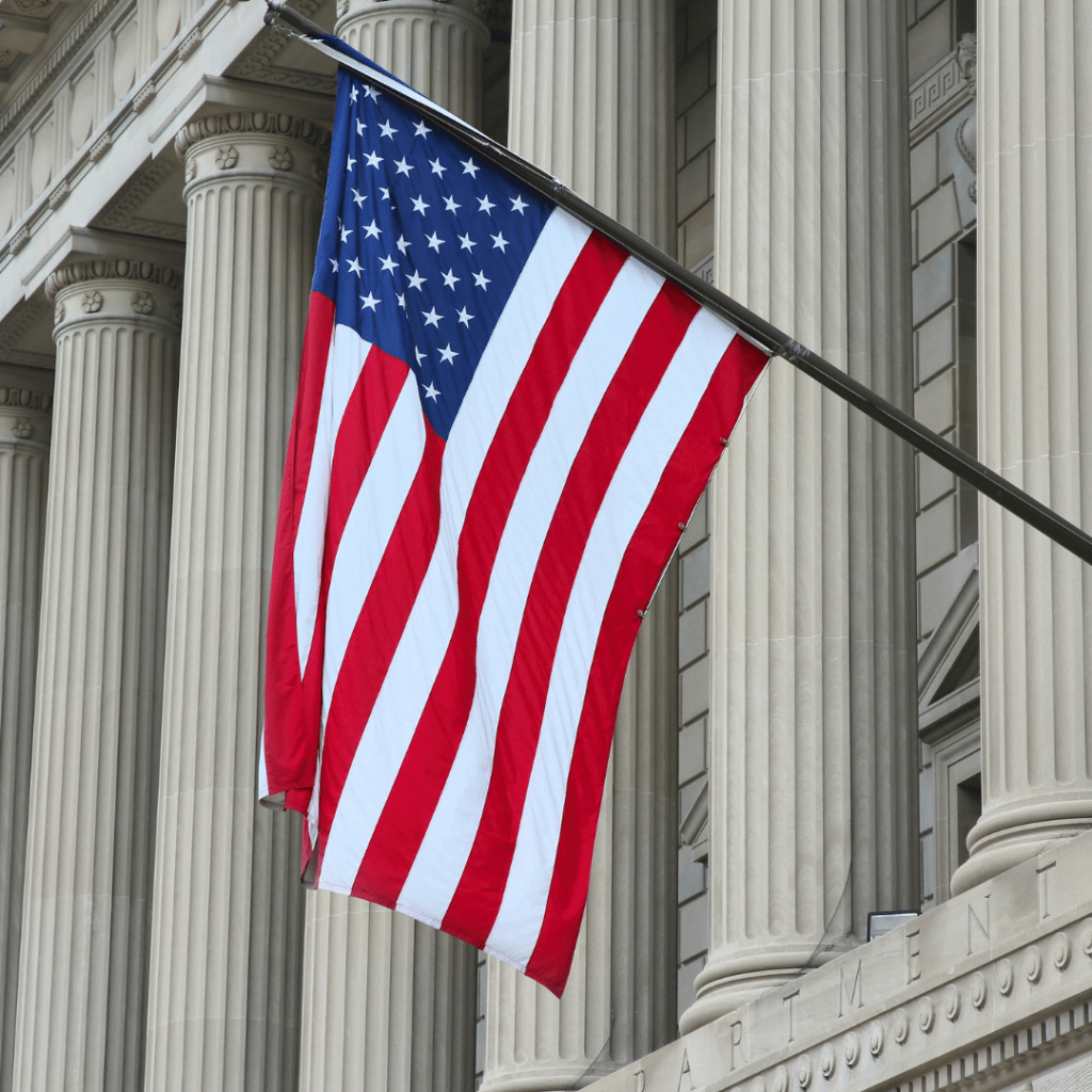 The flag of the United State of America in front a federal building.